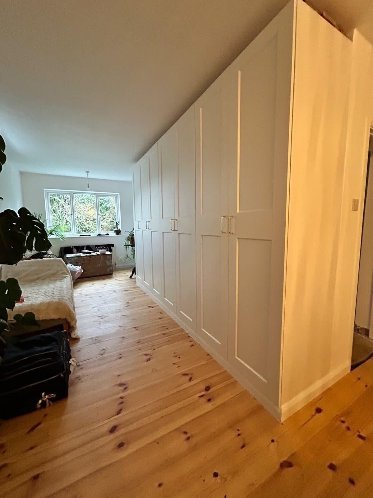 Fitted wardrobes by SINA Kitchen Fitters running the full length of a bedroom wall