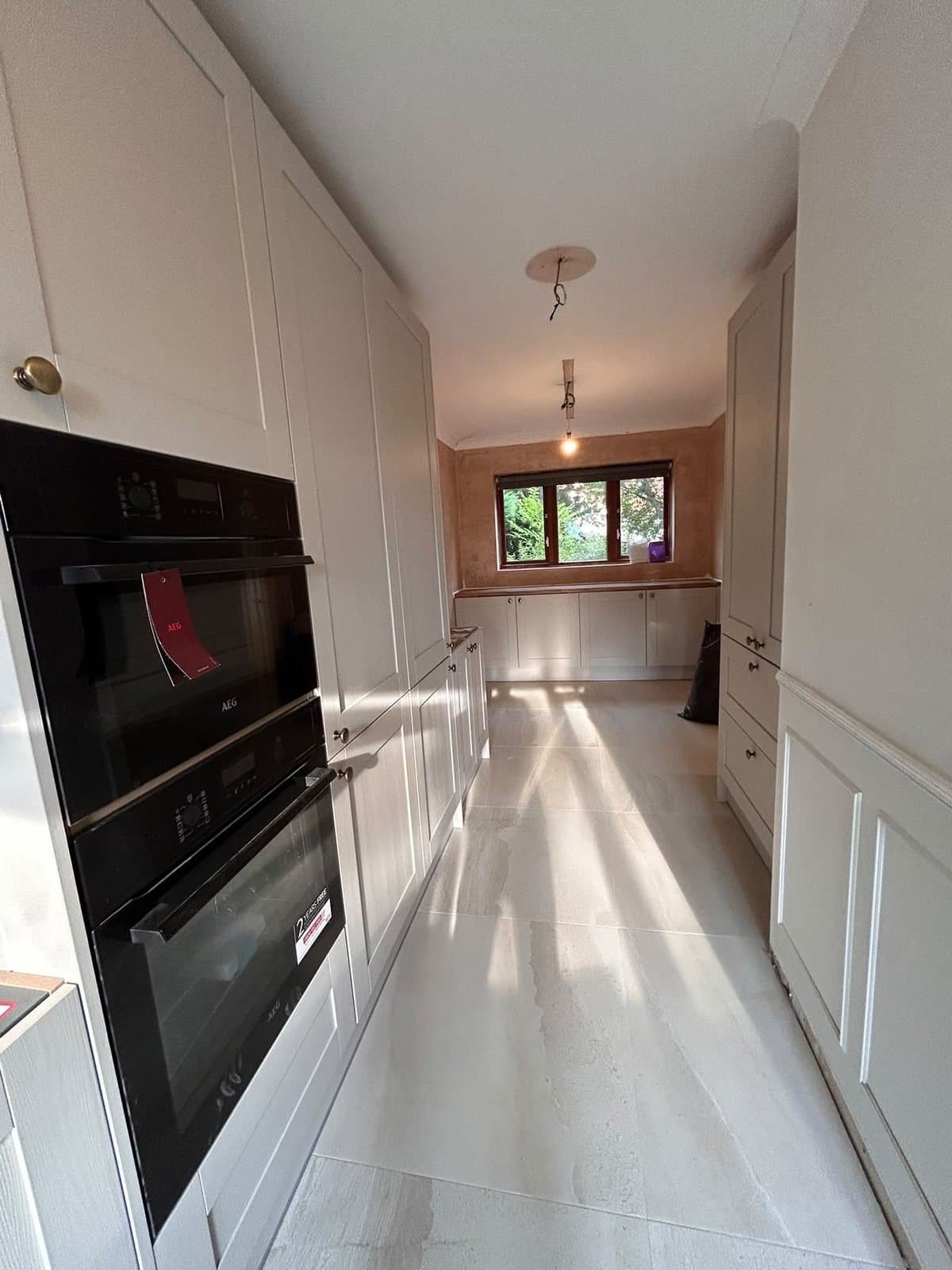 Finished galley kitchen fitted by SINA Kitchen Fitters: tall units and a built-in double oven