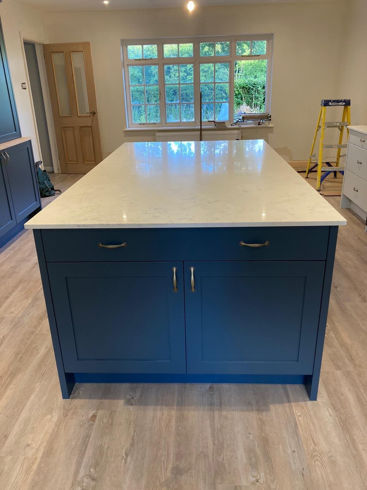 Finished kitchen fitted by SINA Kitchen Fitters: navy shaker island with a white worktop