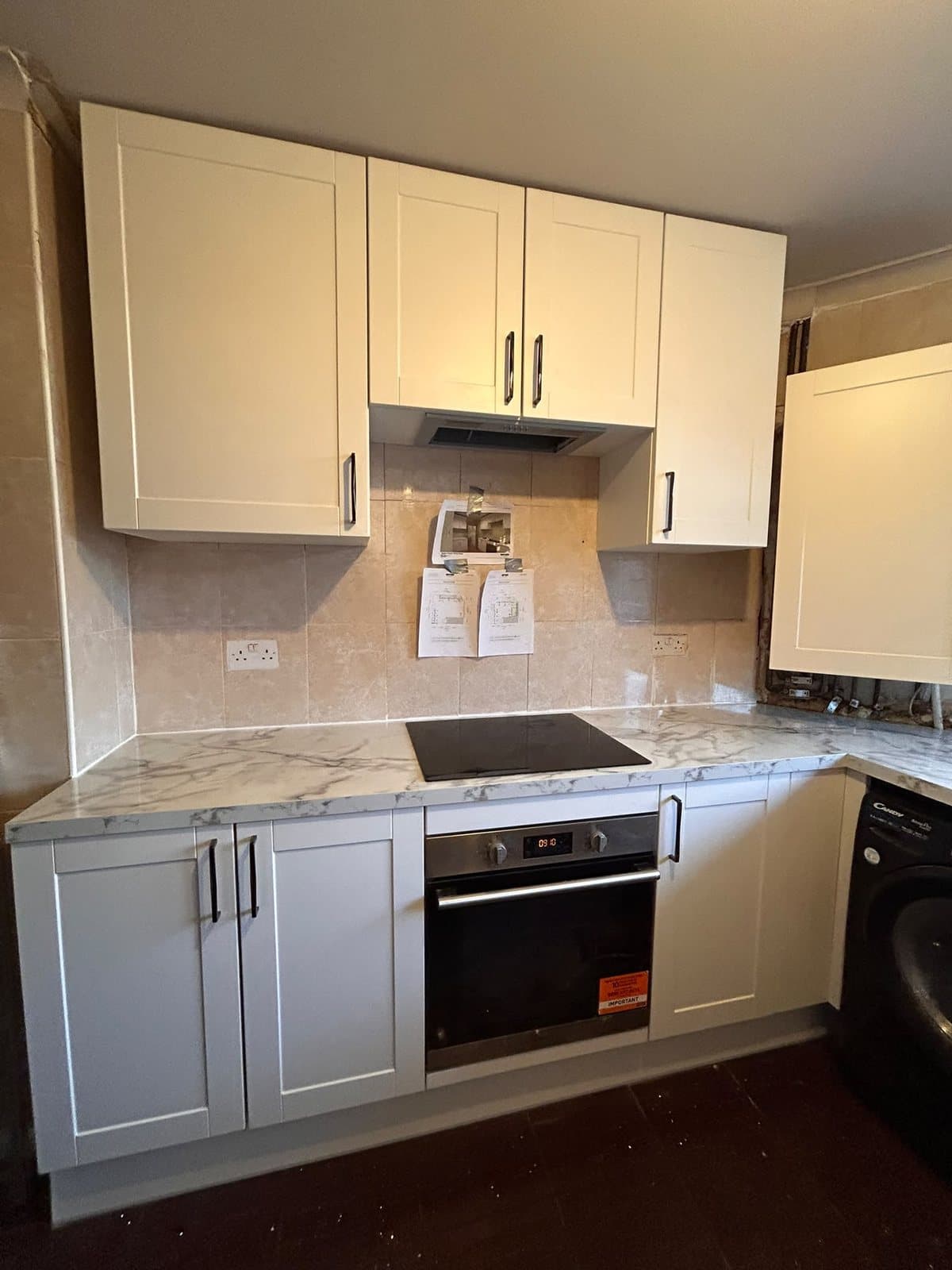 Finished kitchen fitted by SINA Kitchen Fitters: white shaker units with a marble-effect worktop and built-in oven